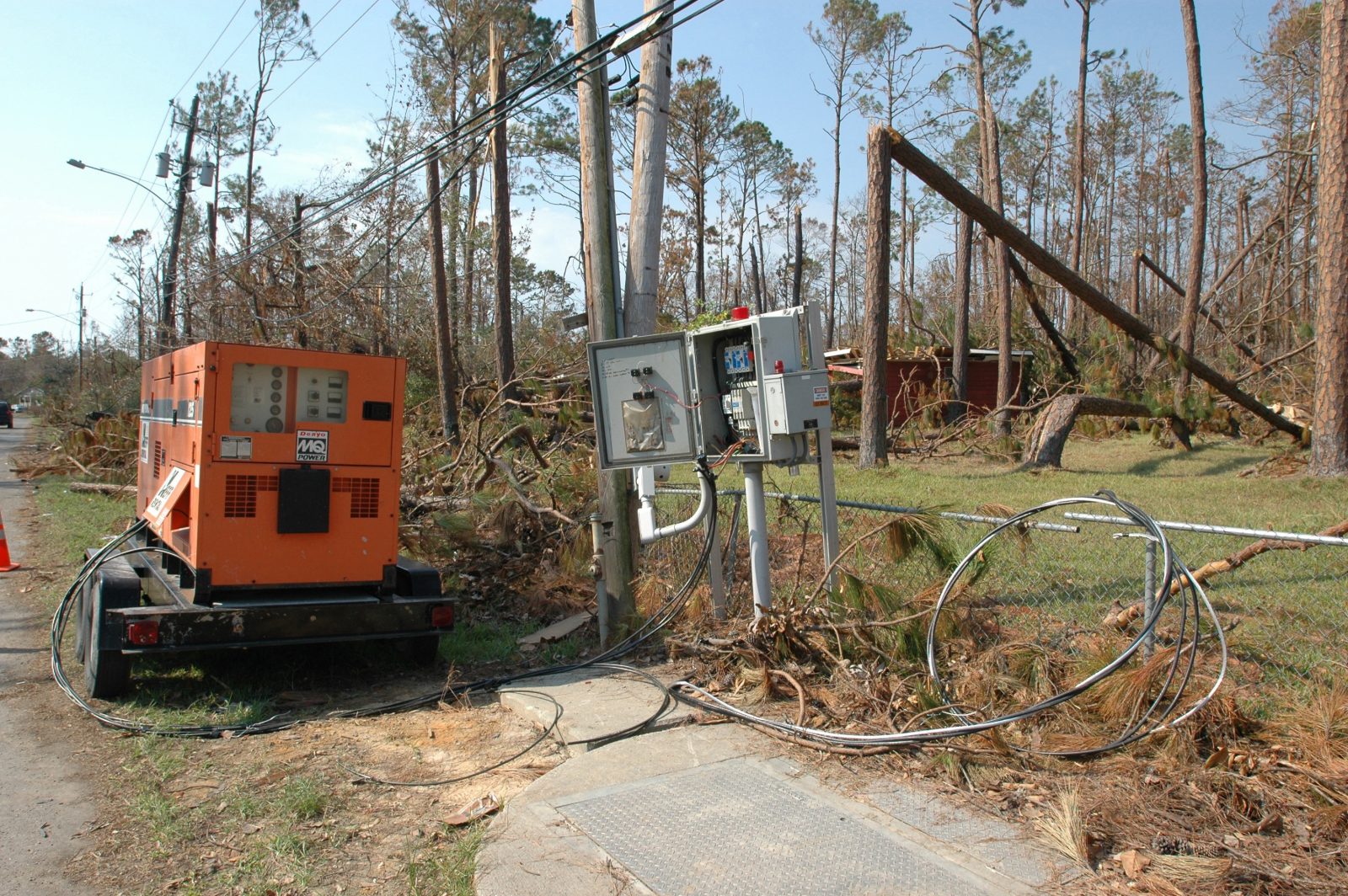 A trailer-mounted generator beside storm-damaged trees and downed power lines in Waveland, Mississippi, after Hurricane Katrina