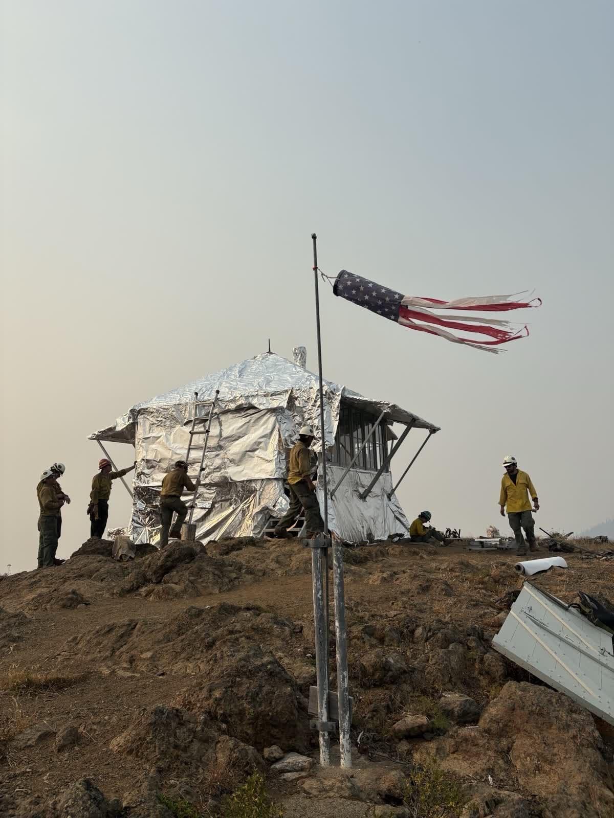 Firefighters wrap the Desolation Peak fire lookout in protective material ahead of the Border 2 Fire, 7 August 2026