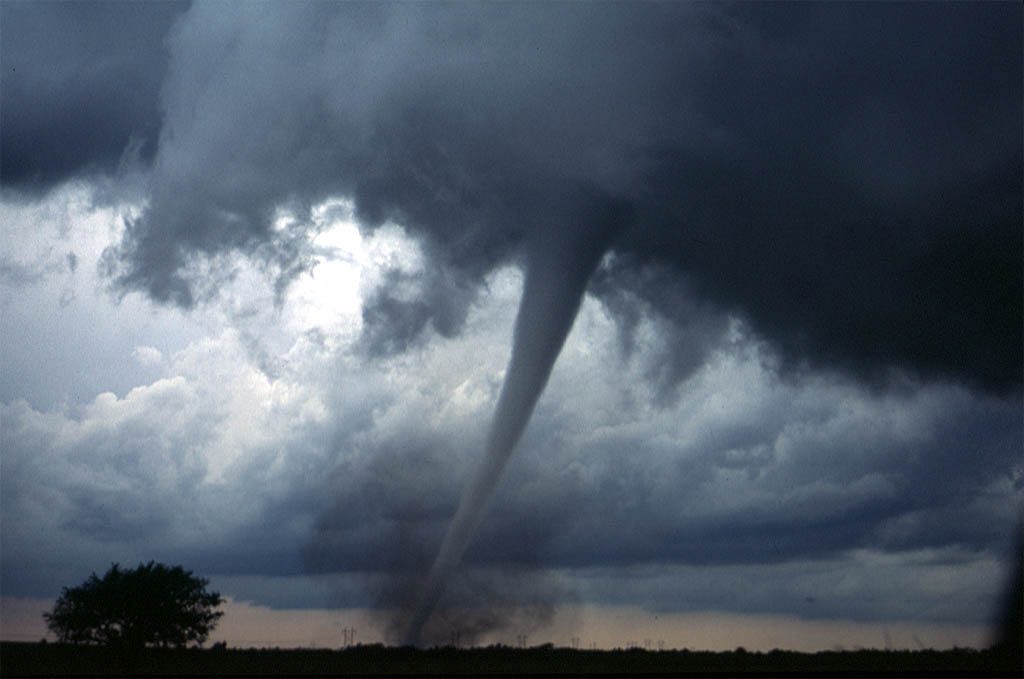 A tornado with a tube-like condensation funnel and surrounding dust cloud near Anadarko, Oklahoma, photographed by the NOAA VORTEX-99 team on 3 May 1999
